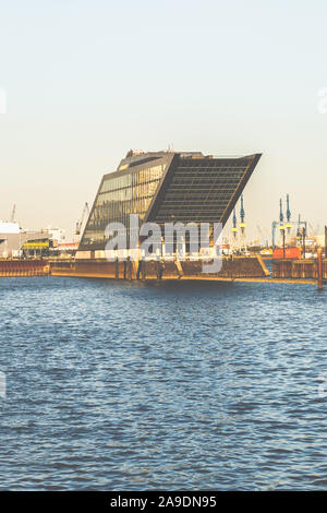 Ein großes Haus in Hamburg an der Elbe, dessen Glasfassade erstrahlt im Sonnenuntergang Stockfoto