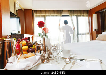 Die junge Frau in einem Hotelzimmer für Kaffee Stockfoto