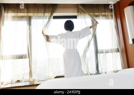Die junge Frau in einem Hotelzimmer für Kaffee Stockfoto