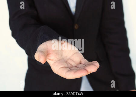 Eine leere Werkstück. Geste der Almosen betteln. Geschäftsmann streckt seine Hand aus. Ein erwachsener junger Mann bittet um Geld. eleganten Gentleman verleihen eine helfende h Stockfoto