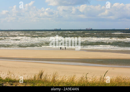 Eine Familie Spaziergänge am Strand von Wangerooge und beobachtet die Schiffe, die in den Horizont, Stockfoto