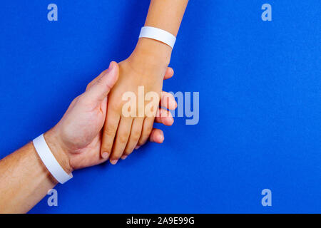 Mockup Vorlage leeres Papier Armband, Armband auf Mann und Kind Waffen, blaue Farbe Hintergrund Stockfoto