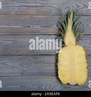 Flach von Ananas halbieren. Weiße Holztisch. Ansicht von oben, Overhead Stockfoto