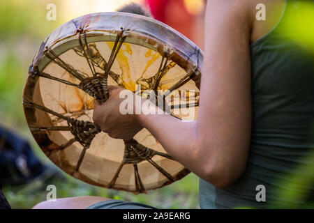 Bis auf den Menschen Hände nahe, wie er spielen Heilige während ein spirituelles Ritual Trommel, holding Native American während einer Musik Feier drum Stockfoto