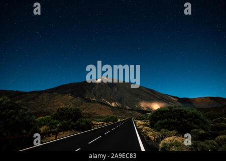 Lange Gerade Asphalt schwarze Straße bei Nacht mit Himmel voller Sterne über-Konzept für Reise und entdecken Sie die Schönheit der Welt - El Teide Vulkan nati Stockfoto