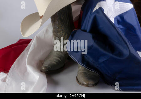 Cowboyhut und Stiefel sind ein Weg des Lebens in Texas durch ruht auf dem Lone Star State Flag. Stockfoto