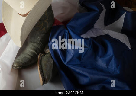 Cowboyhut und Stiefel sind ein Weg des Lebens in Texas durch ruht auf dem Lone Star State Flag. Stockfoto