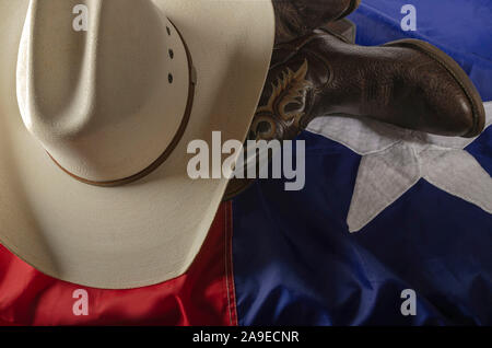 Cowboyhut und Stiefel sind ein Weg des Lebens in Texas durch ruht auf dem Lone Star State Flag. Stockfoto