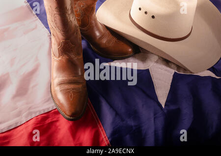 Cowboyhut und Stiefel sind ein Weg des Lebens in Texas durch ruht auf dem Lone Star State Flag. Stockfoto