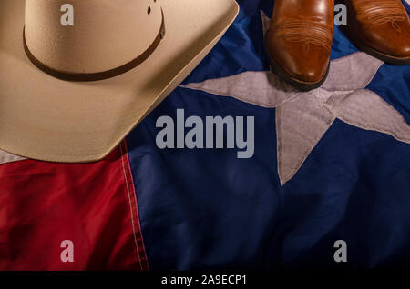 Cowboyhut und Stiefel sind ein Weg des Lebens in Texas durch ruht auf dem Lone Star State Flag. Stockfoto