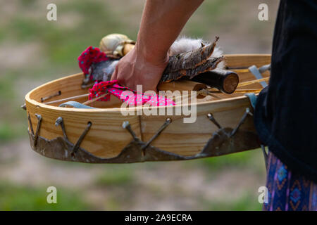Eine Nahaufnahme einer Hand, die eine traditionelle native drum, Drumsticks und Holzstücke, während einer Musik Feier im Park Stockfoto