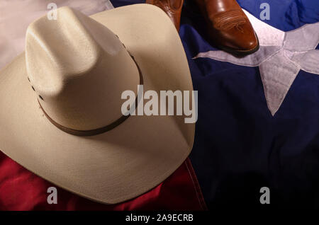 Cowboyhut und Stiefel sind ein Weg des Lebens in Texas durch ruht auf dem Lone Star State Flag. Stockfoto