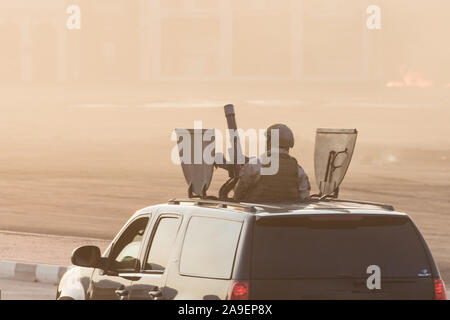 Militär Armee SUV-Fahrzeug in der Nähe von Waffen und militärischen Personal zielen und schießen. Militär und Krieg Konzept der Macht, Kraft, Stärke. Stockfoto