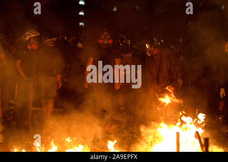 Studierende vor dem Feuer steht eine noch nie dagewesene Schlachten an der Chinesischen Universität Hongkong (Cuhk). Hongkong protestieren kontinuierlich an ihrem fünften Monate. Einen stadtweiten Streik forderte am Montag, 11. November 2019 begonnen, die Teile von Hong Kong zu stoppen als MTR-Stationen geschlossen und mehrere Straßensperren errichtet wurden. Hong Kong, 12.11.2019 Stockfoto