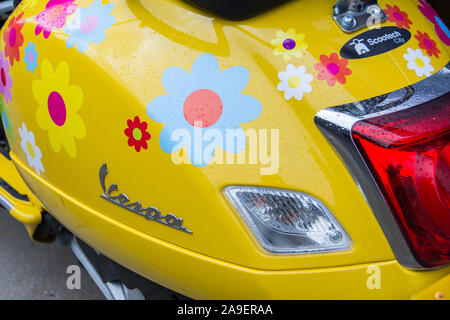 Eine helle gelbe Piaggio Vespa Roller in Central London, UK Stockfoto