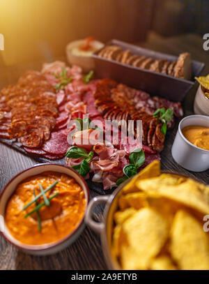 Tabelle mit Vorspeisen, Aufschnitt, Nachos und Dips Willkommen Stockfoto