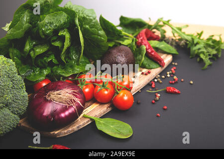 Rohes Gemüse mit frischen Zutaten für Sie gesund Kochen auf schwarzem Hintergrund, Ansicht von oben. Veganer oder Diät Lebensmittel Konzept. Stockfoto