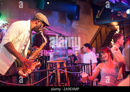 Live Musik auf der Bourbon Street bei Nacht in New Orleans. Diese historische Straße im Französischen Viertel ist bekannt für sein Nachtleben und Live Music Bars. Stockfoto