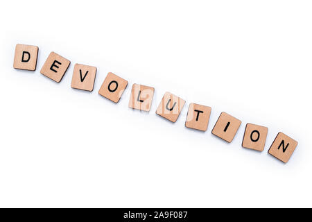 Das Wort DEVOLUTION, Dinkel mit hölzernen Buchstabensteine über einen weißen Hintergrund. Stockfoto