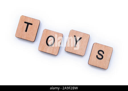 Das Wort Spielzeug, Dinkel mit hölzernen Buchstabensteine über einem weißen Hintergrund. Stockfoto