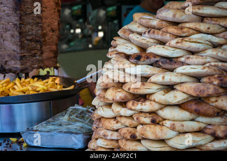 Türkisches Brot, lavash, Pide oder Fladenbrot in Haufen mit Kartoffelchips und Kebab auf dem Hintergrund Stockfoto