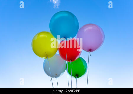 Helle Ballons gegen den klaren, blauen Himmel im Hintergrund Stockfoto