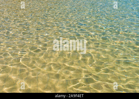 Klar, unberührte Wasser mit Sonnenlicht Flecken. Natur Textur Hintergrund Stockfoto