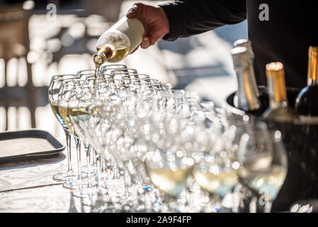 Detail von einem Kellner gießt Sekt in den Gläsern, Szene aus einer Hochzeit, dof Stockfoto