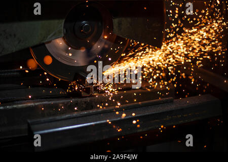 Arbeiten auf Metall. Die Funken fliegen von hoher Reibung. Schneiden von Metall mit der Kreissäge. Arbeit in der Werkstatt. Männer arbeiten in der Garage. Erstellen einer Metall stru Stockfoto