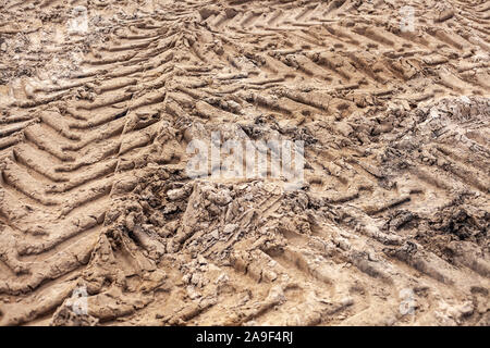Reifenprofil markiert. Abdrücke im Sand von einem Bulldozer. Sand Textur auf einer Baustelle. Mit Füßen sand. Off-road für ein normales Auto. Stockfoto