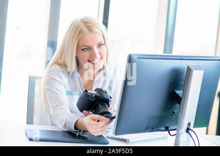 Professionelle Fotografen in ihrem Büro Schreibtisch sitzen und Lächeln. Stockfoto