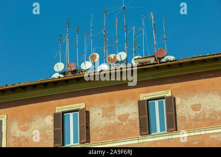 Fernsehantennen und Satellitenschüsseln auf dem Dach. Stockfoto