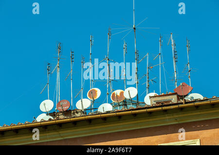 Fernsehantennen und Satellitenschüsseln auf dem Dach. Stockfoto