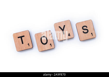 London, UK, 27. März 2019: Das Wort Spielzeug, Dinkel mit hölzernen Buchstabensteine über einem weißen Hintergrund. Stockfoto