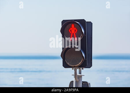 Das grüne Licht der Ampel auf dem Fußgängerüberweg einer menschlichen Silhouette. Stockfoto