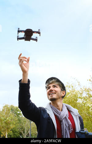 Junger Mann mit Fernbedienung Landung Drone in Seinen Händen Stockfoto