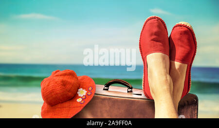 Beine mit rotem Tuch Schuhe vor der Strand und das Meer. Stockfoto