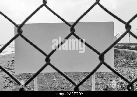 Leere Gefahr oder Warnung durch Maschendrahtzaun - Platz für Ihren eigenen Text. Blaclk und weißes Bild Stockfoto