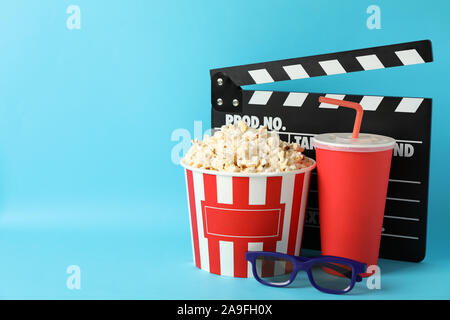 Klappe, Schaufel mit Popcorn, Getränken und 3D-Brille auf blauem Hintergrund Stockfoto