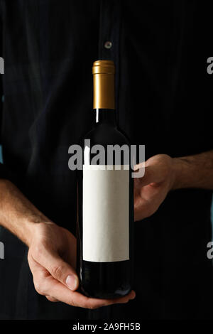 Mann im Hemd Halten Sie Flasche Wein mit leeren Raum Stockfoto