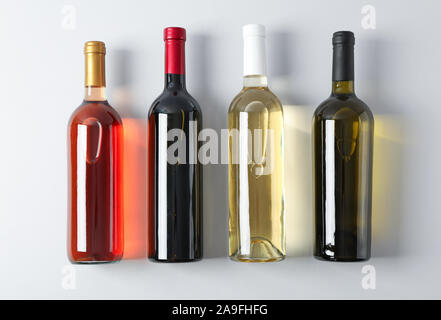 Flaschen mit verschiedenen Wein auf grauem Hintergrund, Ansicht von oben Stockfoto