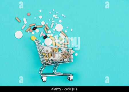 Miniatur Warenkorb mit Pillen, Tabletten und Kapseln abgefüllt: Apotheke einkaufen, Arzneimittel- und Drogenmissbrauch Konzept Stockfoto