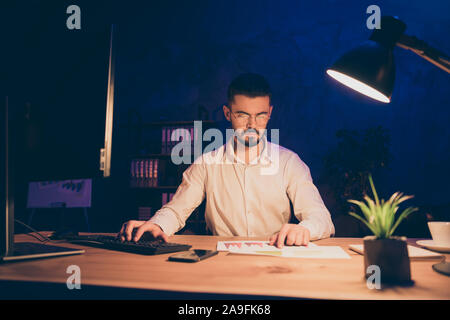 Foto von Ernst nachdenklich grübeln Mann Informationen analysieren Sie mit Hilfe der Grafiken erhalten und Vergleich mit Daten in PC-Tragen einer Brille Stockfoto