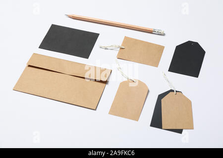 Umschlag, Tags und Bleistift auf weißem Hintergrund, mockup Stockfoto