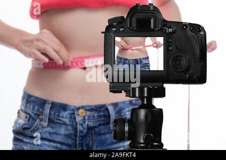 Asiatische vlogger messen Taille hinter der Kamera, social media Produktion Konzept Stockfoto