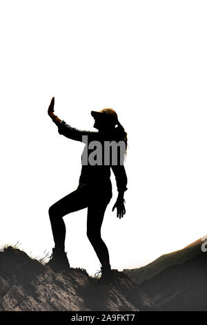 Weibliche Silhouette in der Victor Pose auf einem Felsen vor weißem Hintergrund Stockfoto