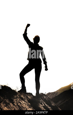 Weibliche Silhouette in der Victor Pose auf einem Felsen vor weißem Hintergrund Stockfoto