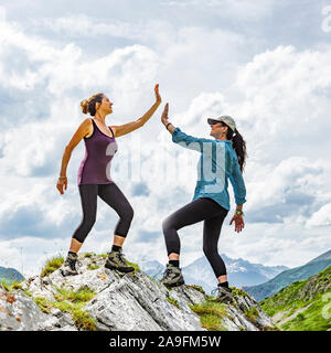 Zwei Frauen klatschen auf einer Bergspitze Stockfoto