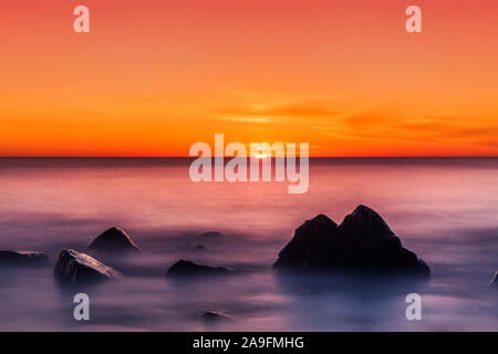 Einen atemberaubenden Sonnenuntergang über dem Meer Stockfoto