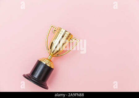 Einfach flach design Sieger oder Meister gold Trophäe Cup auf rosa Pastell bunten Hintergrund isoliert. Sieg den ersten Platz des Wettbewerbs. Sieg oder Erfolg Konzept. Ansicht von oben kopieren Raum Stockfoto